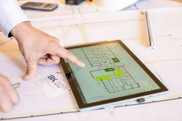 Brandschutzingenieur bei der Arbeit am Flucht- und Rettungswegplan auf einem Tablet
